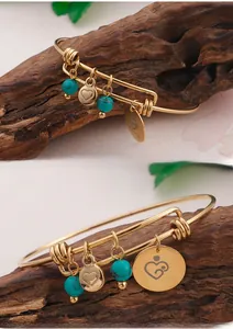 Detail of gold Happy Mother's Day open bangle with turquoise beads and heart charms