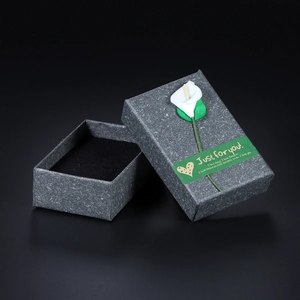 Minimalist dark gray kraft paper jewelry box with white calla lily and interior velvet pad