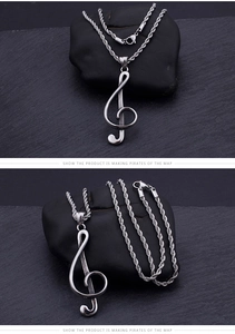 Detailed view of silver treble clef pendant with twisted rope chain on stone background