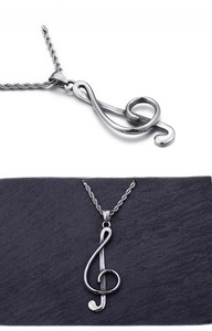 Macro shot of silver music treble clef pendant with vintage finish on a twisted chain
