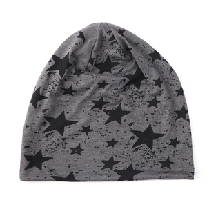 Gros plan d'un bonnet gris en maille avec motifs d'étoiles noires et coton doux