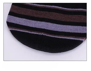 Close-up of the meticulous stitching on the top of the striped knit beanie hat