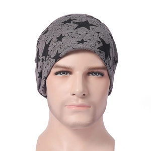 Détail du bonnet en tricot gris avec étoiles noires et motif taches d'encre sur mannequin