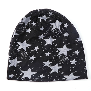 Détail de la texture du tricot sur un bonnet noir avec des motifs d'étoiles grises usées