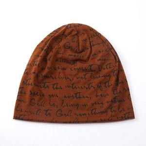Detail of caramel knitted beanie with stylish black cursive script print on cotton fabric