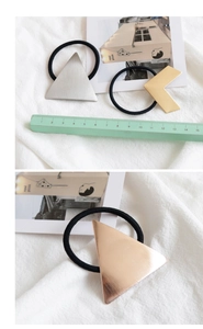 Detail view of geometric metal hair ties showing measurements and metallic texture