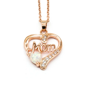Macro shot of rose gold heart pendant with white opal and Mom lettering detail