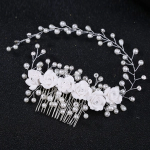 Silver bridal hair comb featuring white ceramic roses, pearls, and crystals on black background