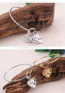 Detail of gold and silver heart pendants with Love engraving and mother-child silhouette
