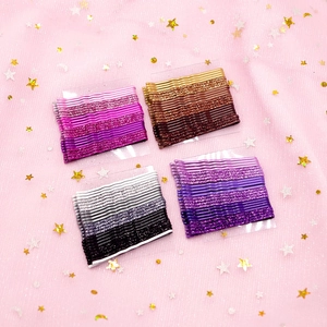 Detailed view of colorful glitter hairpins arranged on a pink star pattern fabric