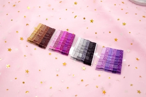Glittery gradient hair pins in brown, pink, and purple colors on a starry tulle background