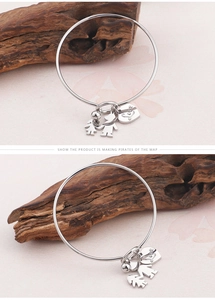 Détail du bracelet en acier titane avec pendentifs garçon, fille et cœur gravé