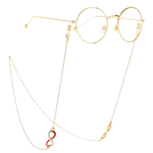 Détail de la chaîne de lunettes dorée avec pendentif symbole infini en strass rouge