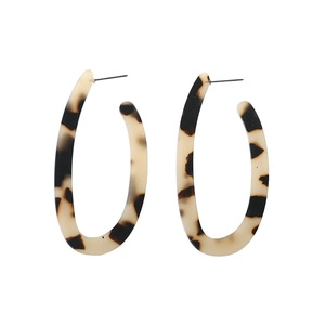 Detailed view of long oval acetate earrings with classic tortoise shell pattern and metal posts