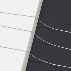 Elegant silver thin metal eyeglass chain with intricate woven links on minimalist background