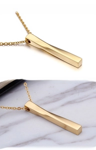 Macro shot of gold twisted rectangle bar pendant on delicate O-link chain necklace