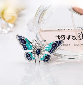 Detailed view of silver butterfly brooch with blue enamel and sparkling rhinestones