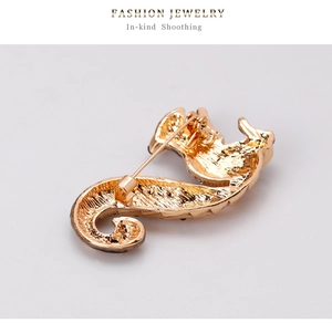 Detailed back view of golden seahorse brooch showing sturdy metal pin and texture