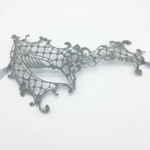 Macro shot of silver lace eye mask showing intricate hollow embroidery and ribbon