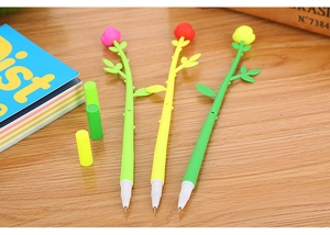 Detailed view of colorful 3D rose flower pens with leaf stems on a wooden desk surface