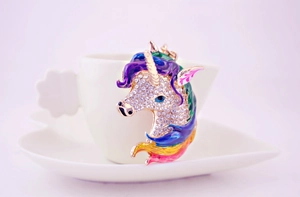Detail of colorful enamel unicorn keychain with sparkling rhinestones on a white saucer