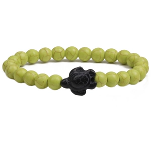 Detailed view of light green turquoise beads with a black turtle charm on elastic cord