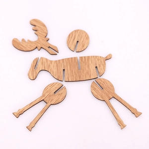 Unassembled wooden Christmas elk DIY puzzle ornament pieces laid on white background