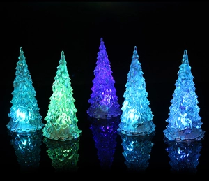Macro view showing five glowing crystal LED Christmas trees with colorful lighting effects