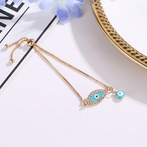 Detail of adjustable gold Evil Eye bracelet with blue enamel and sparkling rhinestones