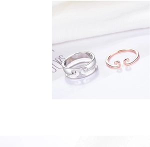 Macro view of couple rings with traditional cloud motifs in silver and rose gold finish