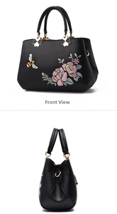 Dettaglio della borsa nera in pelle con ricami colorati di api e fiori eleganti