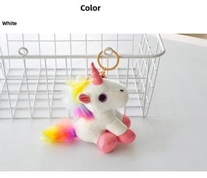 Detail of a white unicorn plush keychain with golden horn and rainbow mane attached to a hook