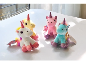 Close-up of colorful unicorn plush keychains in pink, blue, yellow and white with sequins