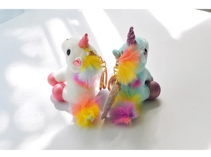 Detail of plush unicorn keychains with rainbow manes and shiny gold metal rings