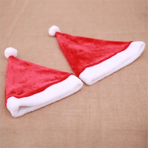 Red plush Christmas hats for adults and kids with white trim on beige linen background