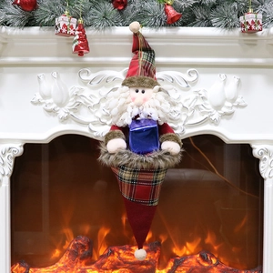 Christmas Santa ornament with red-green plaid pattern hanging on a white fireplace