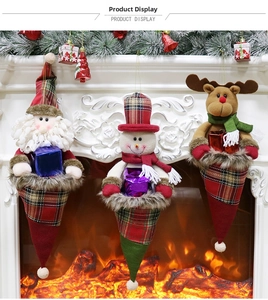 Close-up of Santa, Snowman, and Reindeer plush ornaments hanging on a festive fireplace