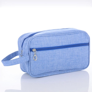 Detail view of light blue travel toiletry bag with canvas texture and metal zipper