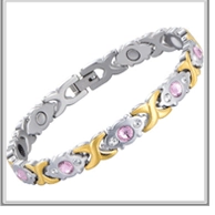 Detail of magnetic healthcare bracelet with two-tone links and pink gemstones
