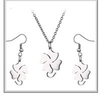 Macro detail of silver stainless steel jewelry set with clover petal pendant and earrings