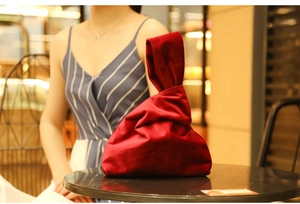 Close-up of premium red velvet evening clutch bag with elegant gold chain handle