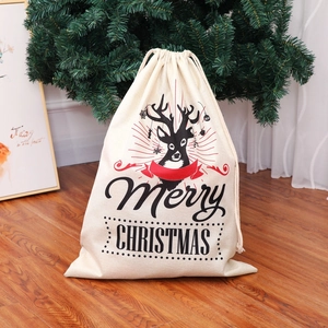 Burlap Christmas drawstring gift bag with reindeer print on wooden floor background