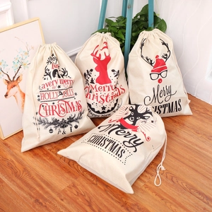 Set of four large linen Christmas gift bags with elk prints and drawstring on wooden floor