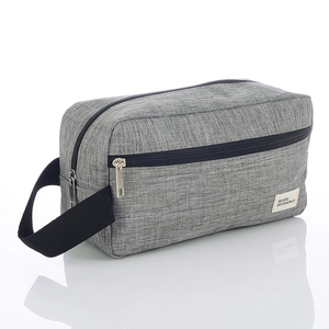 Gray fabric toiletry bag with black zippers and side handle for travel organization