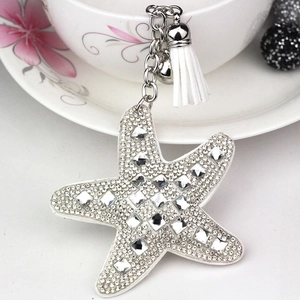 Macro detail of starfish keychain featuring white rhinestones and a silk tassel charm