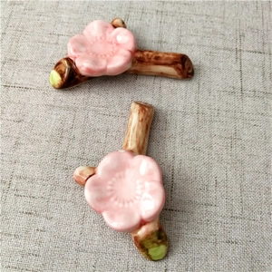 Detailed view of hand-painted pink cherry blossom ceramic chopstick rests on linen