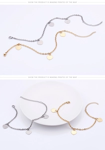 Détail de bracelets de cheville cœur en finitions or et argent sur un plat en céramique