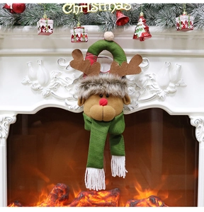 Detail of plush reindeer Christmas door hanging ornament displayed on a festive fireplace