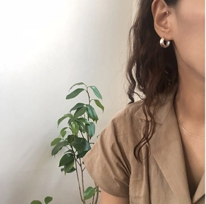 Minimalist 925 sterling silver geometric hoop earrings worn by a model in a side profile view