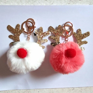 Detail of pink and white plush reindeer keychains with gold sequined antlers and metal clip